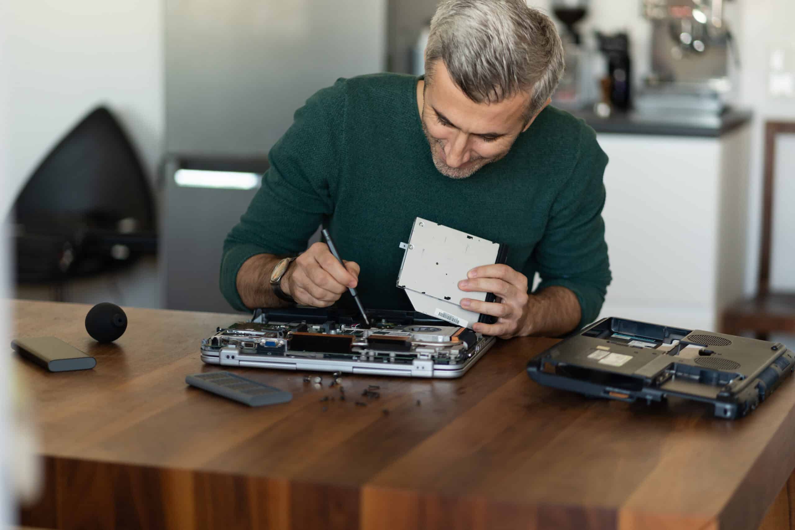 man-repairing-laptop-2023-11-27-05-02-33-utc